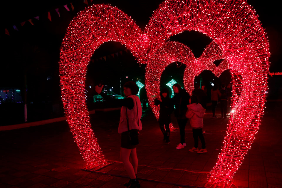 Các bạn trẻ thích thú ghi lại khoảng khắc đẹp dưới ánh sáng lung linh. (Ảnh: Việt Dũng/TTXVN)