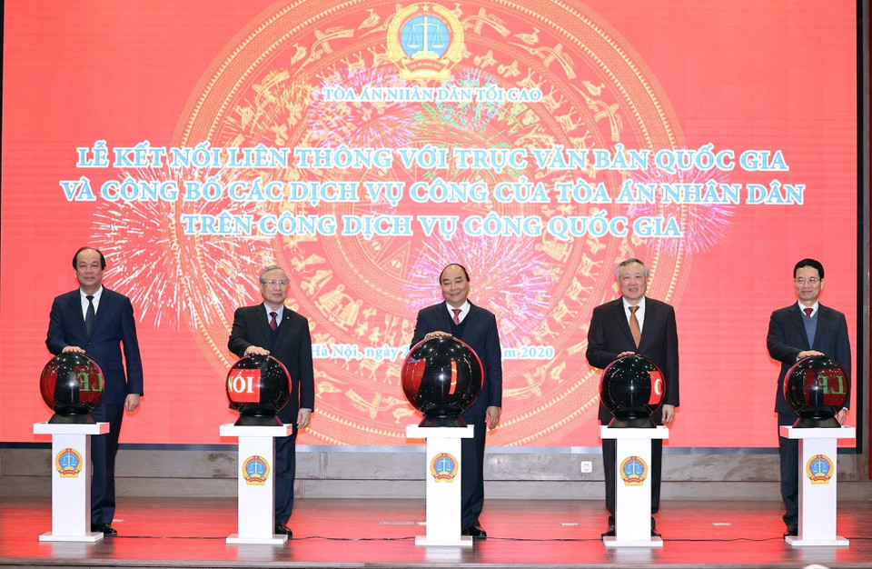Thủ tướng Nguyễn Xuân Phúc và các đại biểu thực hiện nghi thức khai trương kết nối liên thông với trục văn bản quốc gia và công bố các dịch vụ công của Tòa án Nhân dân trên Cổng dịch vụ công quốc gia. (Ảnh: Thống Nhất/TTXVN)