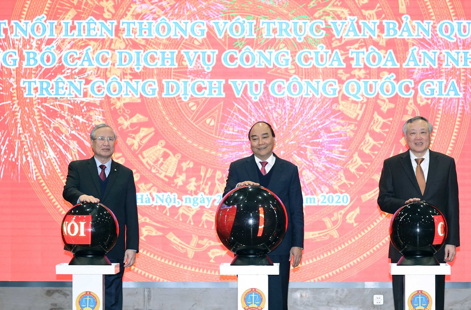 Thủ tướng Nguyễn Xuân Phúc và các đại biểu thực hiện nghi thức khai trương kết nối liên thông với trục văn bản quốc gia và công bố các dịch vụ công của Tòa án Nhân dân trên Cổng dịch vụ công quốc gia. (Ảnh: Thống Nhất/TTXVN)