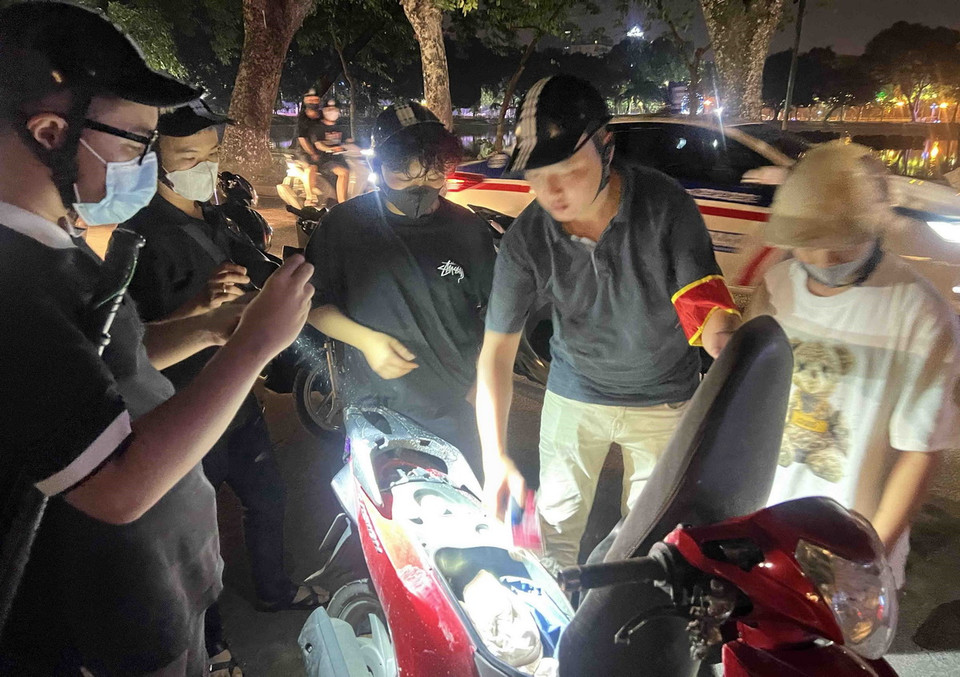Một trường hợp đi xe máy lạng lách, đánh võng đã bị tổ công tác Y9/141 hoá trang bắt giữ tại phố Nguyễn Du trong đêm 31/8. (Ảnh: Phạm Kiên/ TTXVN)