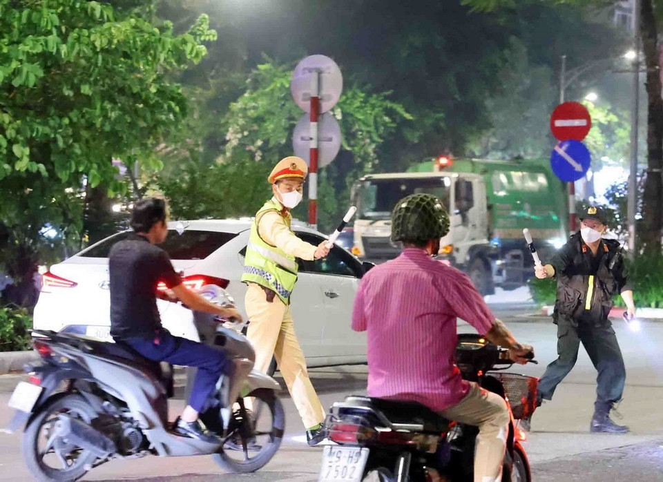 Cán bộ, chiến sỹ thuộc tổ công tác liên ngành Y6/141 dừng xe kiểm tra và xử lý 1 trường hợp vi phạm giao thông tại phố Trần Khát Chân. (Ảnh: Phạm Kiên/TTXVN)