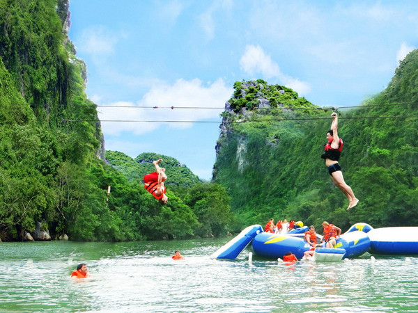 Du khách tham gia dịch vụ du lịch đu dây trên không tại tuyến du lịch sông Chày-hang Tối. (Ảnh: Đức Thọ-Mạnh Thành/TTXVN)