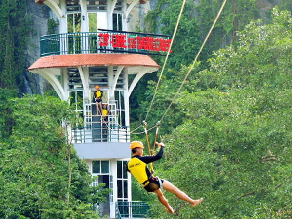 Du khách tham gia dịch vụ du lịch đu dây trên không tại tuyến du lịch sông Chày-hang Tối. (Ảnh: Đức Thọ-Mạnh Thành/TTXVN)