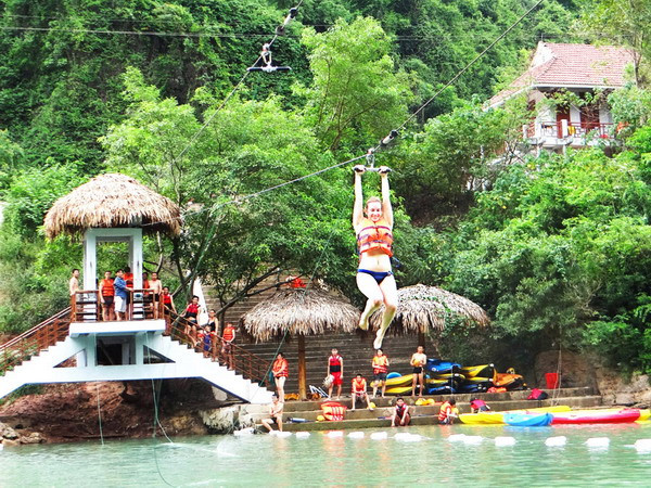 Du khách tham gia dịch vụ du lịch đu dây trên không tại tuyến du lịch sông Chày-hang Tối. (Ảnh: Đức Thọ-Mạnh Thành/TTXVN)