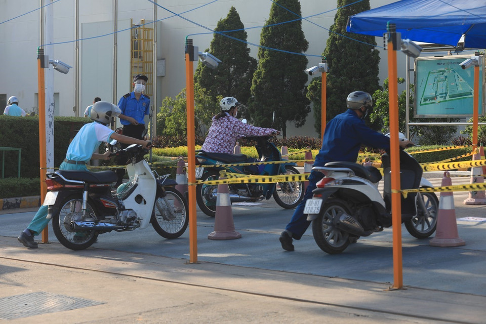 Công nhân Công ty TOTO Việt Nam vào làm việc phải thực hiện đầy đủ các biện pháp 5K. (Ảnh: Phan Tuấn Anh/TTXVN)