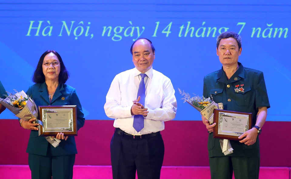 Thủ tướng Nguyễn Xuân Phúc tặng biểu trưng và hoa cho các cựu thanh niên xung phong tiêu biểu tại Lễ kỷ niệm 70 năm Ngày truyền thống lực lượng Thanh niên xung phong Việt Nam (15/7/1950-15/7/2020) và tôn vinh các điển hình tiến tiến thanh niên xung phong qua các thời kỳ. (Ảnh: Thống Nhất/TTXVN)
