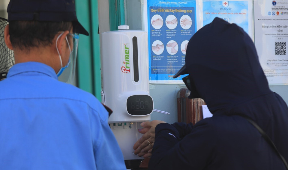 Máy đo thân nhiệt và dung dịch sát khuẩn được đặt ngay tại cổng trước khi vào công ty. (Ảnh: Phan Tuấn Anh/TTXVN)