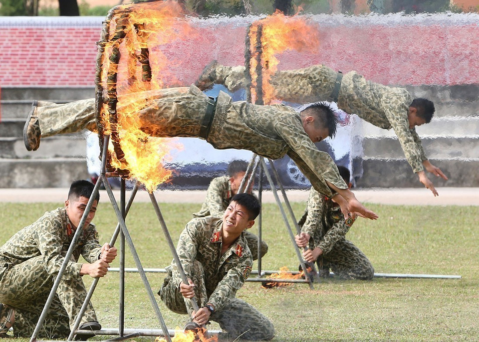Bộ đội Đặc công trình diễn các kỹ thuật phi thân qua vòng lửa.(Ảnh: Trọng Đức/TTXVN)