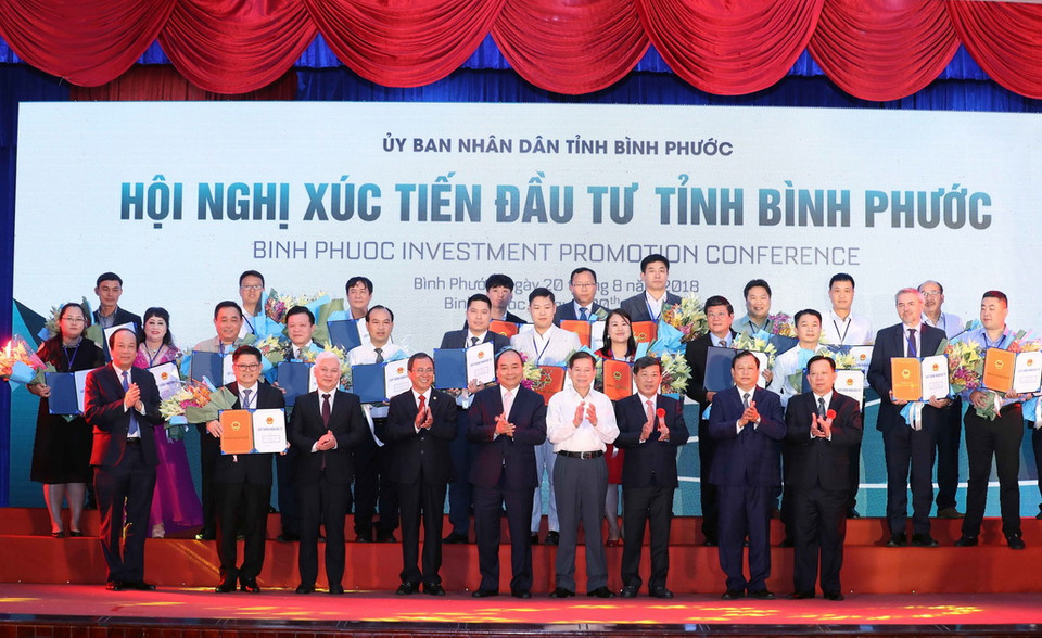 Thủ tướng Nguyễn Xuân Phúc chụp ảnh chung với các doanh nghiệp nhận giấy chứng nhận đăng ký đầu tư, quyết định chủ trương đầu tư vào tỉnh Bình Phước. (Ảnh: Thống Nhất/TTXVN)