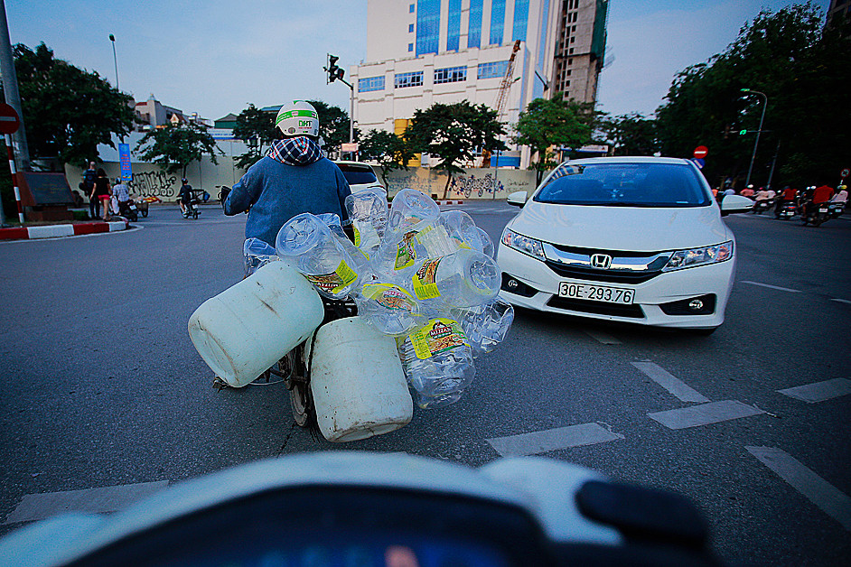 Một người phụ nữ chở những chai nhựa thu lượm được để bán lại cho các cơ sở thu mua, tái chế hoặc tái sử dụng, và cũng có thể sẽ lại trở thành rác thải hủy hoại môi trường. (Ảnh: Trọng Đạt/TTXVN)