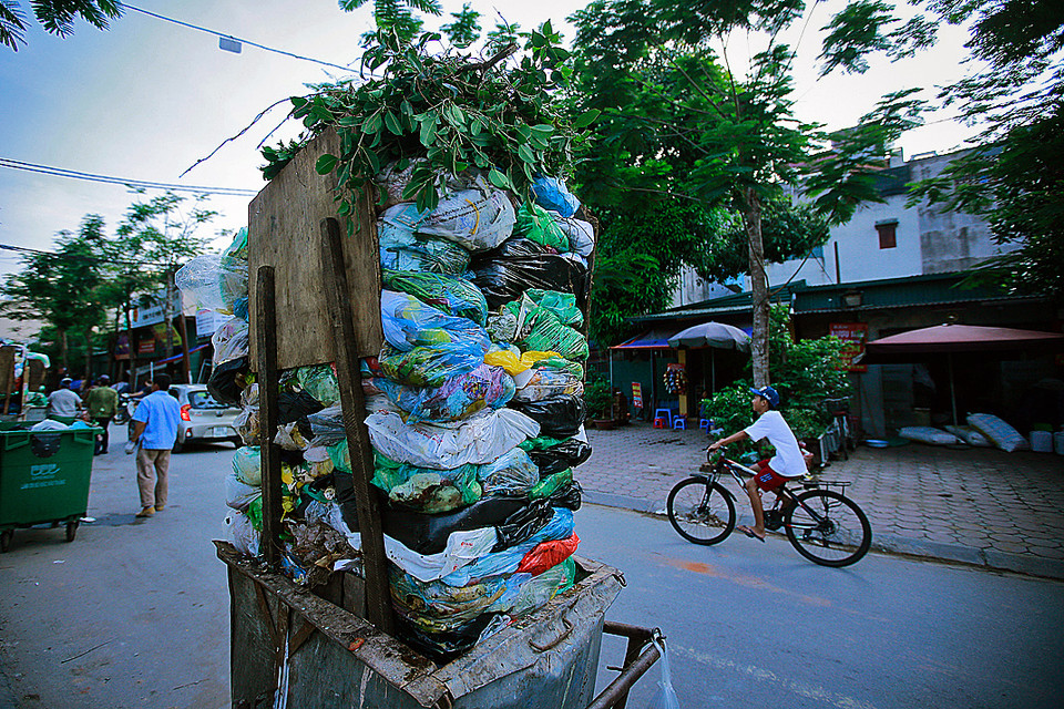 Một xe thu gom rác với rất nhiều túi nilon đựng rác chất cao quá đầu người ở ngõ 274 Đội Cấn, quận Ba Đình, Hà Nội. Thói quen sinh hoạt gắn liền với túi nilon của con người đang vô hình góp phần vào việc hủy hoại môi trường sống của chính mình. (Ảnh: Trọng Đạt/TTXVN)