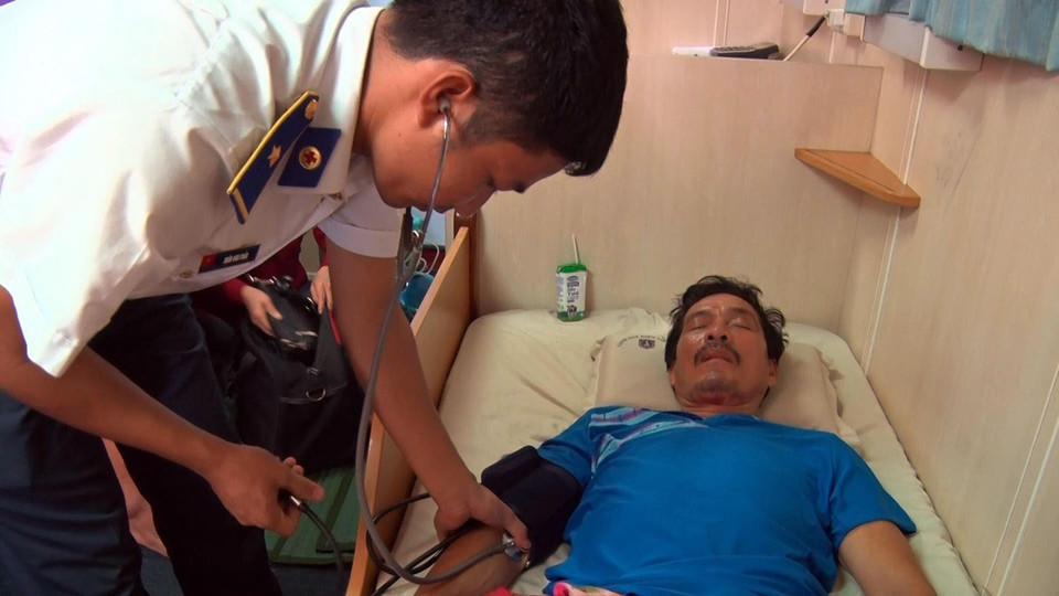 Bác sĩ quân y Bộ Tư lệnh Vùng Cảnh sát biển 4 khám sức khỏe cho ngư dân bị tai nạn khi đang hành nghề trên biển, được tàu Cảnh sát biển đến cứu, đưa vào đất liền điều trị, ngày 15/9/2017. (Ảnh: Lê Sen/TTXVN)