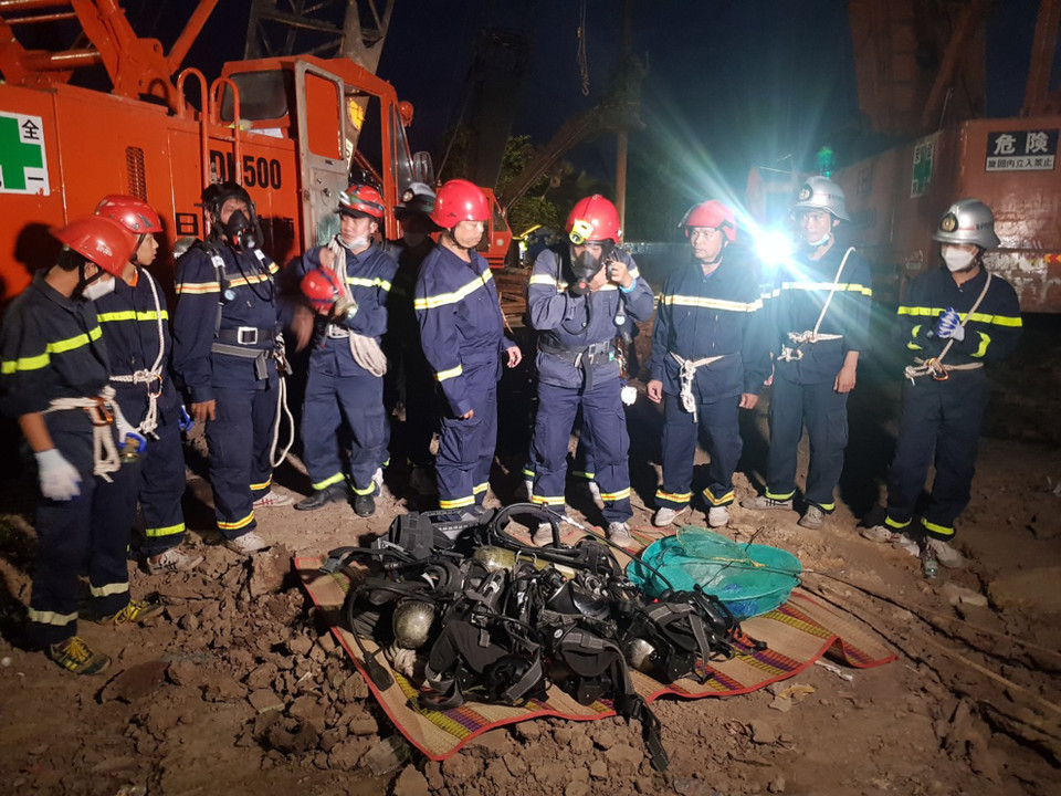 Lực lượng phòng cháy chữa cháy và cứu nạn, cứu hộ Công an tỉnh Đồng Tháp đeo thiết bị chuyên dụng để tìm và đưa thi thể bé Nam lên mặt đất. (Ảnh: TTXVN phát)