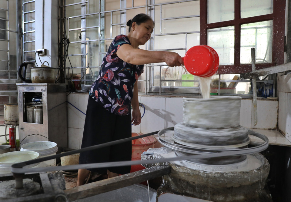 Gạo ngon được đem ngâm nước rồi xay nhuyễn để tạo thành thứ bột nhỏ mịn và trắng muốt để tráng bánh. (Ảnh: Danh Lam/TTXVN)