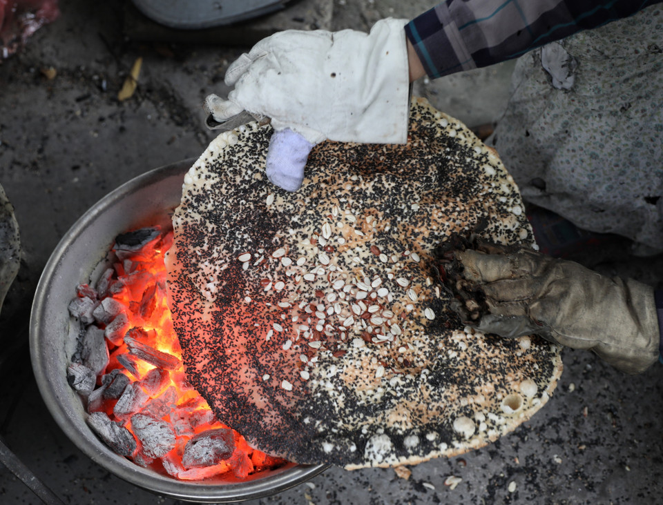 Công đoạn nướng bánh đa Kế đòi hỏi phải lật lên lật xuống kết hợp uốn nắn, chỉnh sao cho bánh tròn đều, chuyển sang màu vàng nhạt và dậy mùi thơm. (Ảnh: Danh Lam/TTXVN)