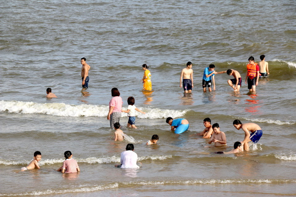 Du khách tắm biển ở bãi biển thành phố Phan Thiết. (Ảnh: Nguyễn Thanh/TTXVN)