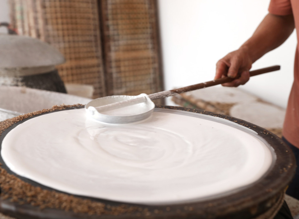 Không chỉ tráng một lần như các loại bánh tráng thông thường mà với bánh đa Kế người ta sẽ tráng 2 lần, khi lớp đầu tiên vẫn còn hơi ướt, lớp bánh thứ hai sẽ được trải đều lên. (Ảnh: Danh Lam/TTXVN)