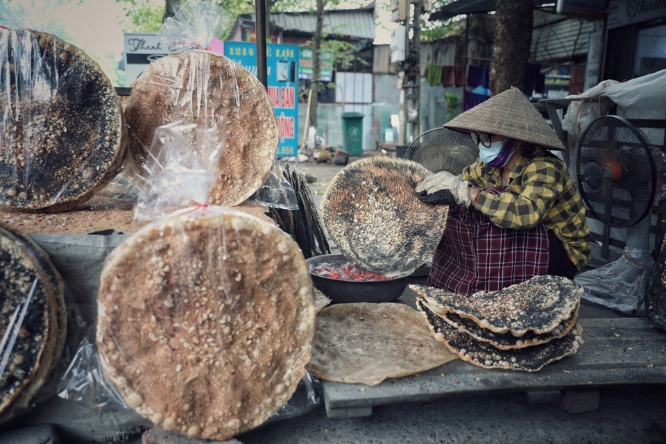Công đoạn nướng bánh đa Kế đòi hỏi phải lật lên lật xuống kết hợp uốn nắn, chỉnh sao cho bánh tròn đều, chuyển sang màu vàng nhạt và dậy mùi thơm. (Ảnh: Danh Lam/TTXVN)