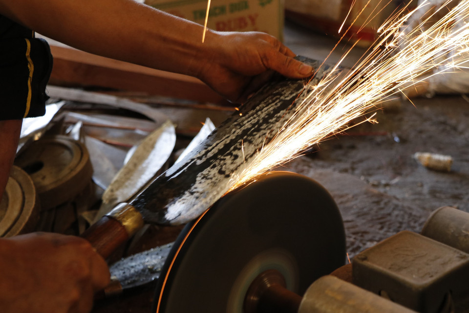 Hoàn tất công đoạn cuối cùng để có một con dao sắc bén và tinh xảo. (Ảnh: Tuấn Anh/TTXVN)