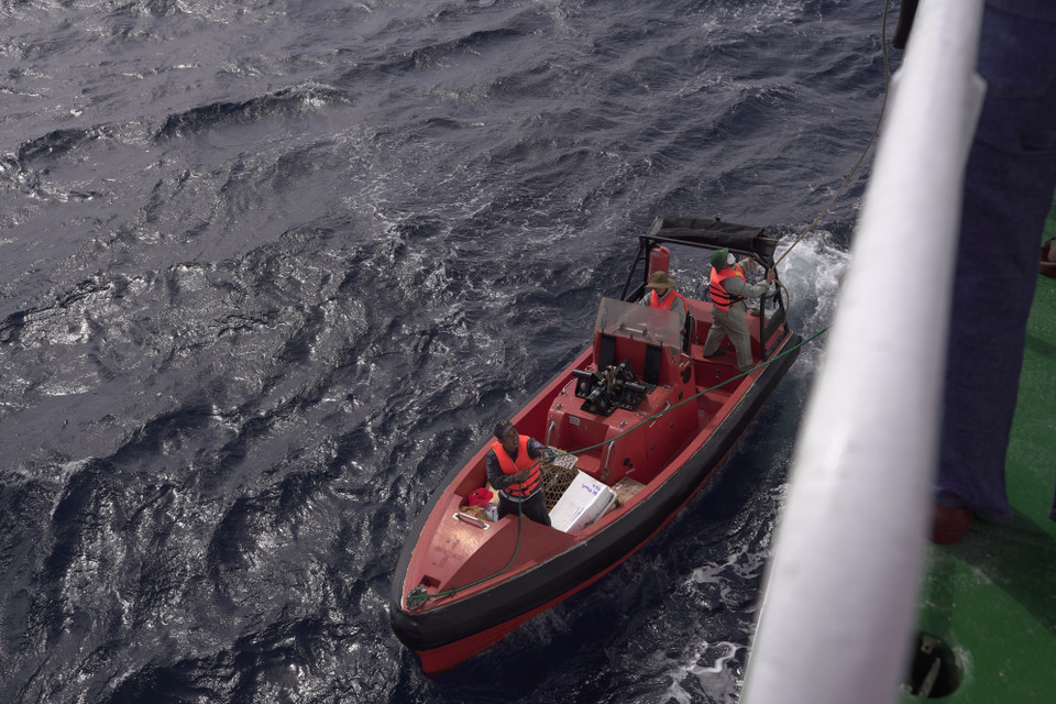 Vận chuyển hàng Tết từ tàu lớn xuống canô ra đảo chìm. (Ảnh: Ngọc Đức/TTXVN)