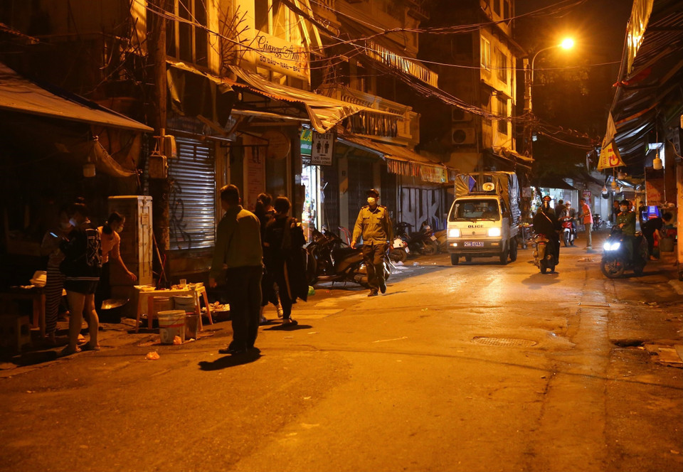 Lực lượng chức năng phường Hàng Bồ (quận Hoàn Kiếm) nhắc nhở các hộ kinh doanh đóng cửa đúng giờ theo quy định.(Ảnh: Hoàng Hiếu/TTXVN)