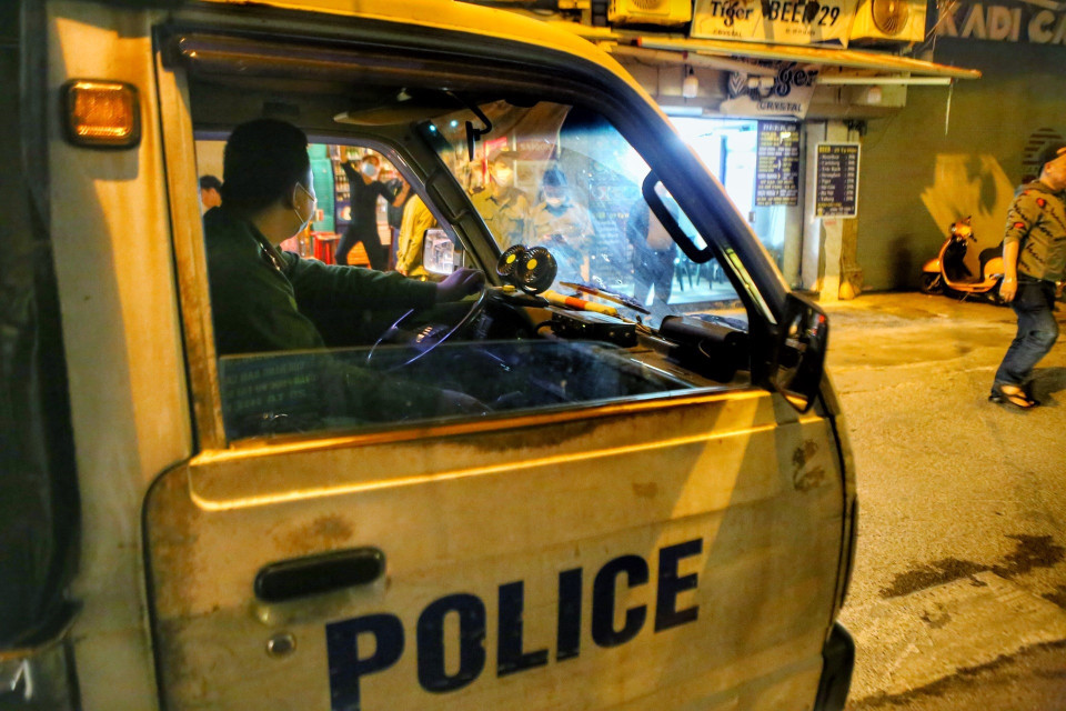 Lực lượng công an phường đi kiểm tra, nhắc nhở các hàng quán tại phố Tạ Hiện, quận Hoàn Kiếm thực hiện nghiêm việc đóng cửa sau 21 giờ. (Ảnh: Tuấn Đức/TTXVN)