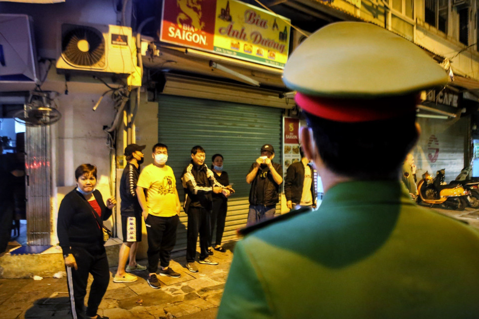 Lực lượng công an phường đi kiểm tra, nhắc nhở các hàng quán tại phố Tạ Hiện, quận Hoàn Kiếm thực hiện nghiêm việc đóng cửa sau 21 giờ. (Ảnh: Tuấn Đức/TTXVN)
