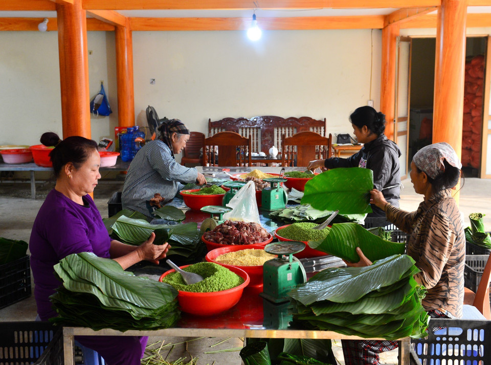 Công việc gói bánh chủ yếu do những người phụ nữ đảm nhiệm. (Ảnh: Nam Thái/TTXVN)