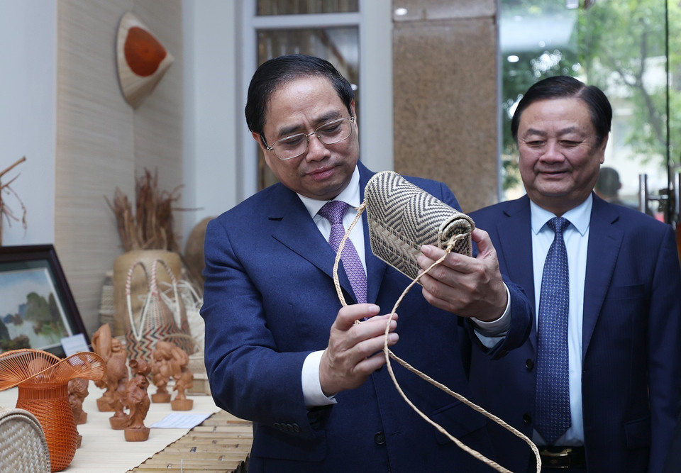 Hình ảnh Thủ tướng Phạm Minh Chính xem trưng bày sản phẩm nông nghiệp, thủ công mỹ nghệ. (Ảnh: Dương Giang/TTXVN)