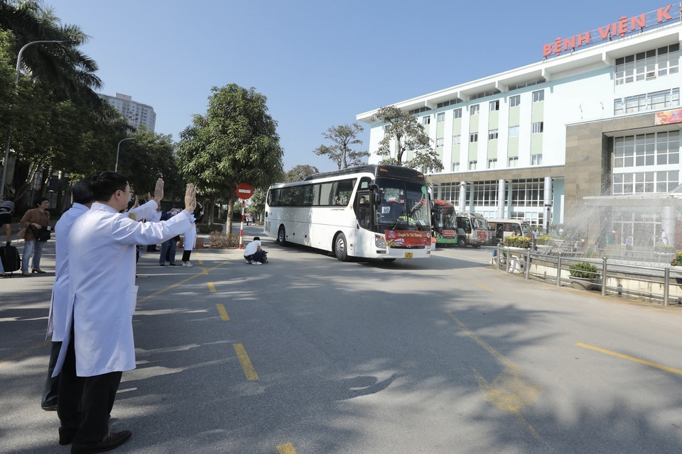 Tập thể lãnh đạo, nhân viên y tế Bệnh viện K tiễn đoàn xe đưa bệnh nhân và người nhà về quê đón tết. (Ảnh: Minh Quyết/TTXVN)