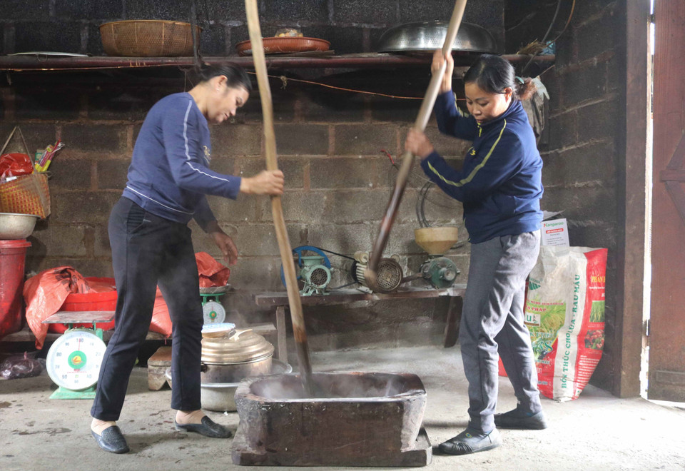 Xôi chín cho ra cối giã nhuyễn dẻo như bánh dày, rồi đổ khoai môn và một ít rượu trắng vào giã cùng đến khi thật nhuyễn và đều. (Ảnh: Chu Hiệu/TTXVN)