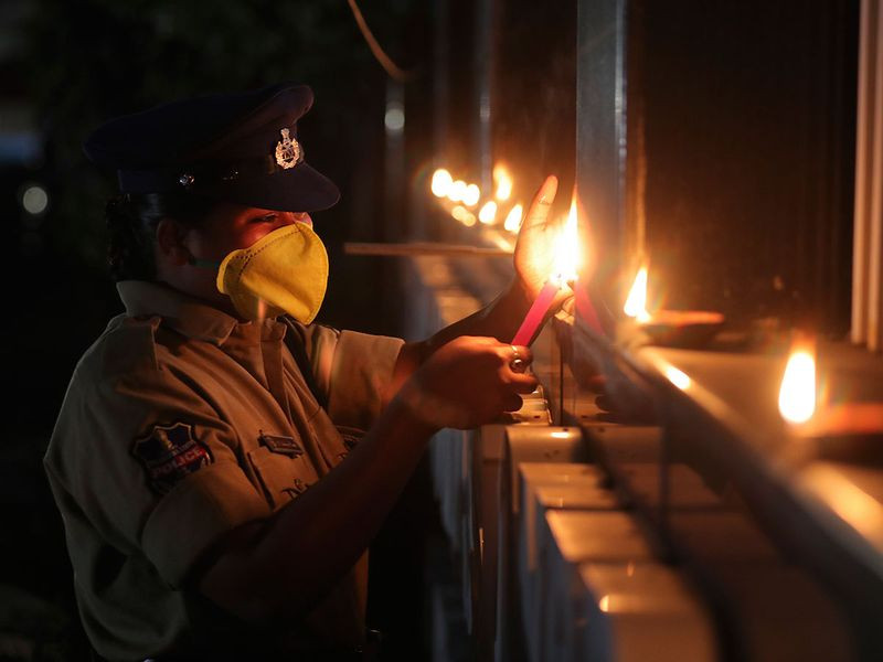 Một nữ cảnh sát Ấn Độ thắp đèn để chung tay cùng đất nuốc chống lại đại dịch COVID-19 tại thành phố Hyderabad, Ấn Độ. (Nguồn: AP)
