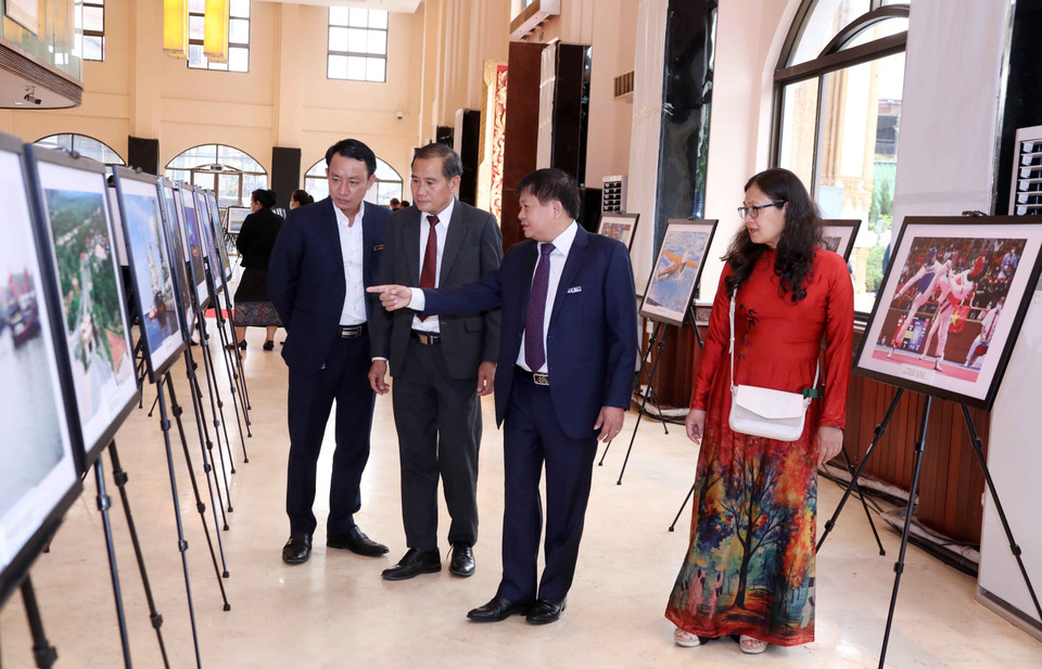 Phó Tổng Giám đốc TTXVN Đinh Đăng Quang và các đại biểu tham quan triển lãm. (Ảnh: Văn Điệp/TTXVN)