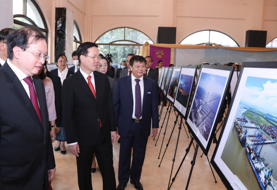 Ủy viên Bộ Chính trị, Thường trực Ban Bí thư Võ Văn Thưởng cùng đại biểu xem các bức ảnh giới thiệu thành tựu phát triển kinh tế của Việt Nam do phóng viên TTXVN thực hiện. (Ảnh: Văn Điệp/TTXVN)