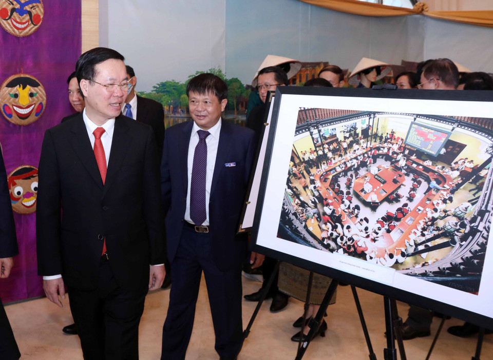 Ủy viên Bộ Chính trị, Thường trực Ban Bí thư Võ Văn Thưởng cùng đại biểu xem các bức ảnh giới thiệu thành tựu phát triển kinh tế của Việt Nam do phóng viên TTXVN thực hiện. (Ảnh: Văn Điệp/TTXVN)