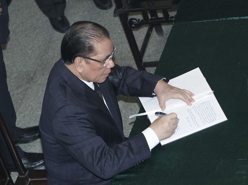 Nguyên Tổng Bí thư Nông Đức Mạnh ghi sổ tang tưởng nhớ nguyên Tổng Bí thư Đỗ Mười. (Ảnh: TTXVN)