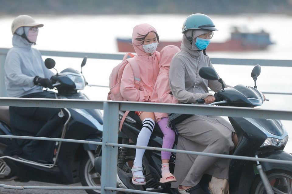 Người dân với trang phục ấm đi trên cầu Long Biên (Hà Nội). (Ảnh: Minh Quyết/TTXVN)