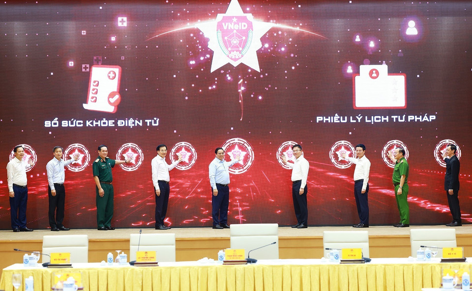 Thủ tướng Phạm Minh Chính và các đại biểu bấm nút khai trương Sổ sức khỏe điện tử và cấp Phiếu lý lịch tư pháp trên VNeID. (Ảnh: Dương Giang/TTXVN)