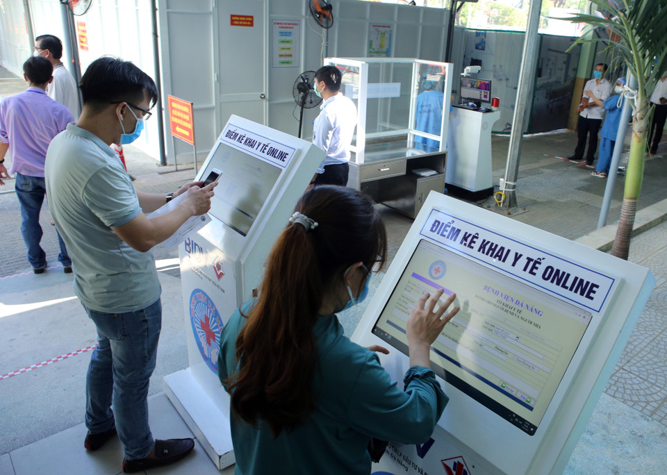 Người dân đến khám bệnh thực hiện khai báo y tế online. (Ảnh: Trần Lê Lâm/TTXVN)