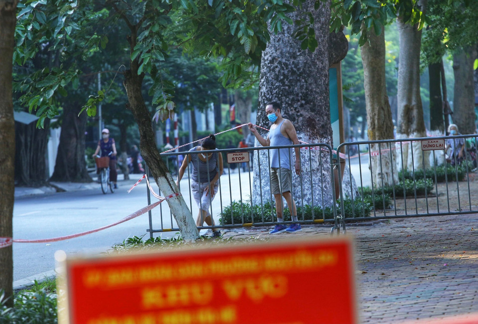 Nhiều người dân vẫn tập thể dục tại khu vực hồ Thiền Quang dù đã được lực lượng chức năng căng dây, cắm biển cấm (ảnh chụp lúc 6h20p ngày 13/7). (Ảnh: Hoàng Hiếu/TTXVN)