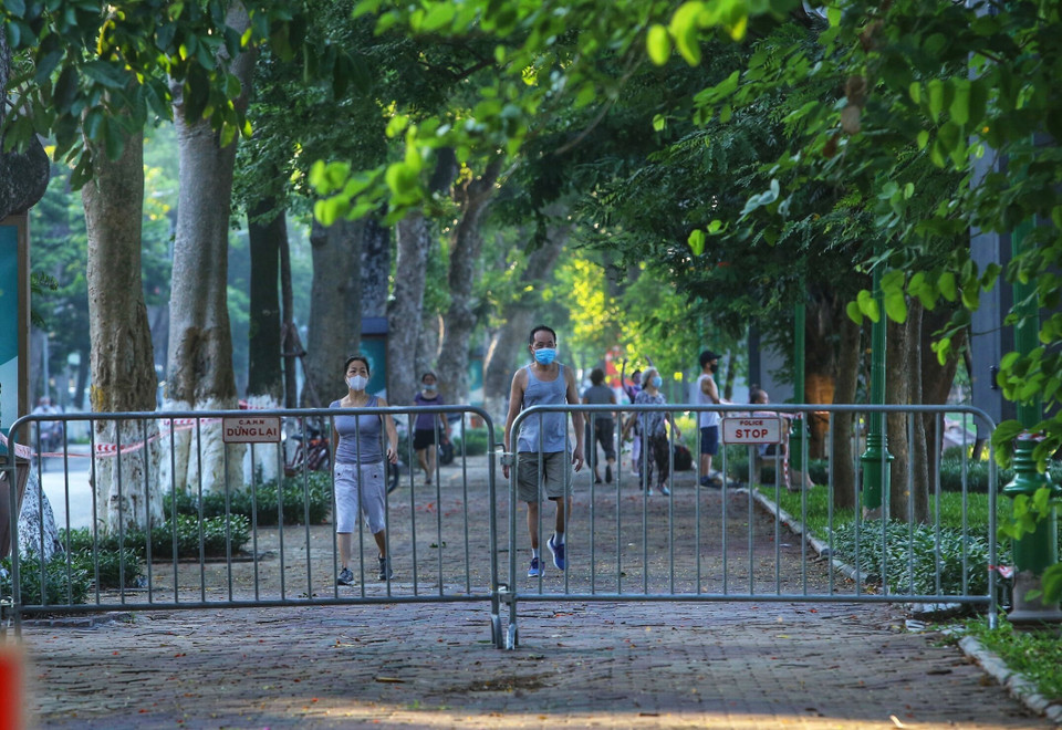 Nhiều người dân vẫn tập thể dục tại khu vực hồ Thiền Quang dù đã được lực lượng chức năng căng dây, cắm biển cấm (ảnh chụp lúc 5h50 ngày 13/7). (Ảnh: Hoàng Hiếu/TTXVN)