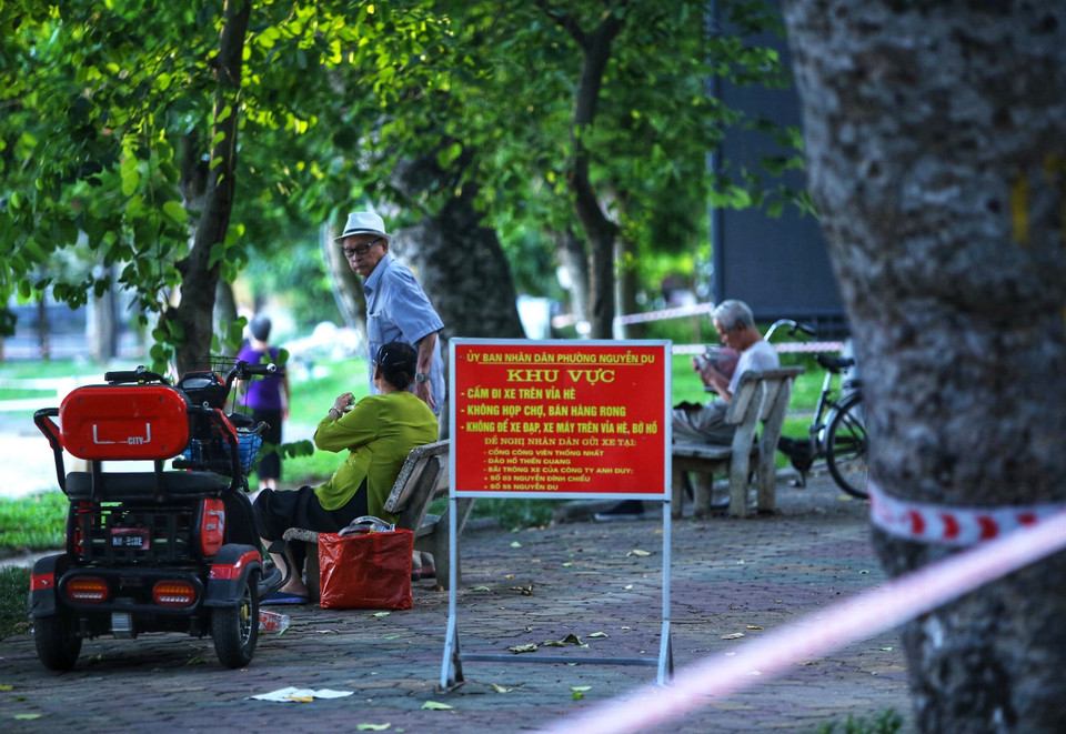 Một số người dân vẫn không đeo khẩu trang, tập thể dục khu vực ven hồ ven hồ Thiền Quang (dù lực lượng Công an phường Nguyễn Du đã căng dây, để biển báo yêu cầu không vi phạm. Ảnh chụp 5h50 ngày 13/7/2021). (Ảnh: Hoàng Hiếu/TTXVN)