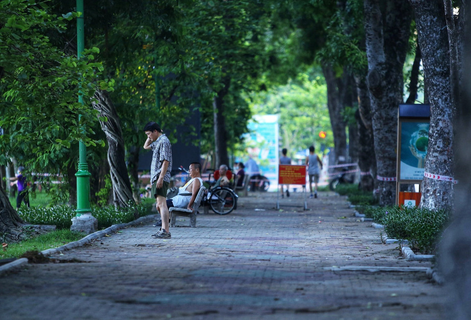 Một số người dân vẫn không đeo khẩu trang, tập thể dục khu vực ven hồ ven hồ Thiền Quang (dù lực lượng Công an phường Nguyễn Du đã căng dây, để biển báo yêu cầu không vi phạm. Ảnh chụp 5h50 ngày 13/7/2021). (Ảnh: Hoàng Hiếu/TTXVN)