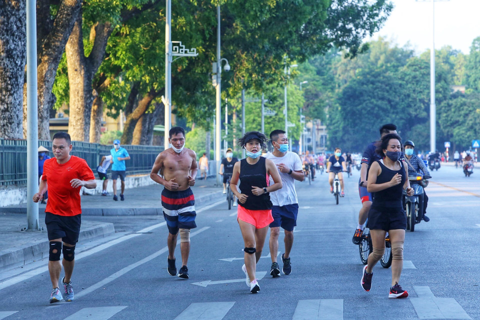 Nhiều người dân vẫn không đeo khẩu trang hoặc đeo không đúng cách khi tập thể dục dù đã có lệnh dừng triệt để đề phòng, chống dịch COVID-19 của UBND Thành phố (ảnh chụp lúc 6h5p ngày 13/7/2021 tại đường Độc Lập). (Ảnh: Hoàng Hiếu/TTXVN)