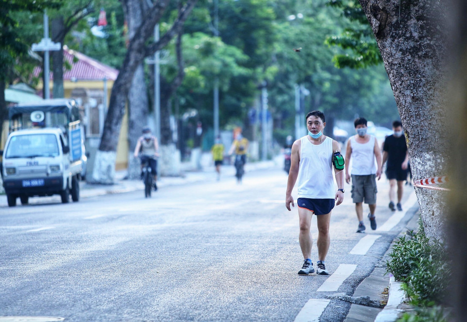 Một số người dân đi tập thể dục vẫn đeo khẩu trang không đúng cách trong lúc tình hình dịch bệnh vẫn còn phức tạp (ảnh chụp lúc 5h55p ngày 13/7 trên đường Nguyễn Du). (Ảnh: Hoàng Hiếu/TTXVN)