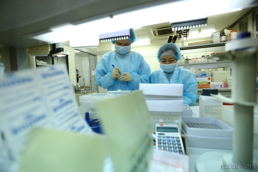 Chuẩn bị thiết bị trước khi phân lập. (Ảnh: Minh Quyết/TTXVN)