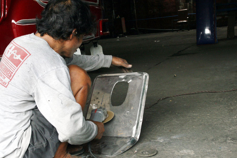 Người thợ đang mài những chi tiết cần thiết cho xe Jeepney. (Ảnh: T.H/Vietnam+)