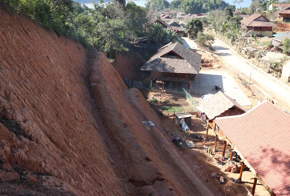 Dù đã bạt cơ, san nền, nhưng vách núi đất cao, dốc đứng vẫn có nguy cơ xảy ra sạt lở, đe dọa đến sự an toàn của những ngôi nhà xây dựng bên dưới. (Ảnh: Xuân Tiến/TTXVN) 