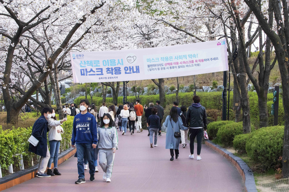 Pano hướng dẫn người dân thực hiện nghiêm quy tắc phòng dịch (đeo khẩu trang) khi đi dạo quanh hồ Seokchon. (Ảnh: Anh Nguyên/TTXVN)