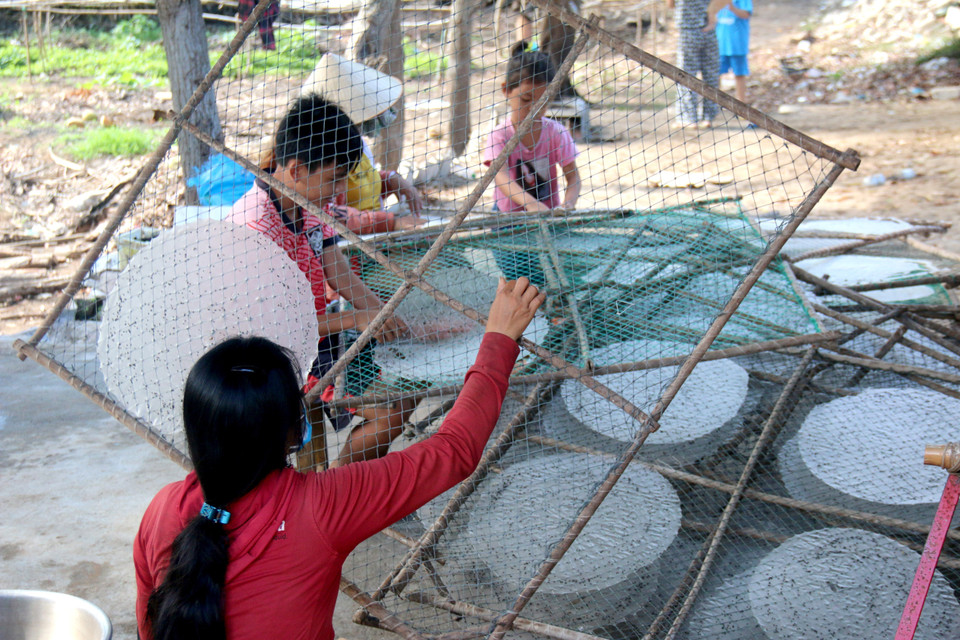 Gỡ bánh sau khi bánh tráng đã được phơi khô. (Ảnh: Nguyễn Thanh/TTXVN)